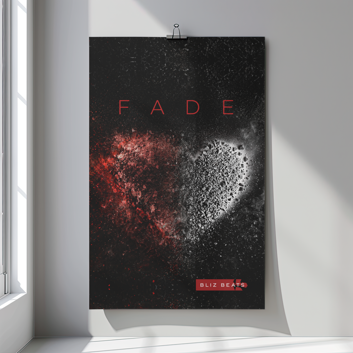 A vertical poster print hanging on a light gray wall, clipped at the top. The artwork has a black background with the word "FADE" in red letters above a heart-shaped split of red and white speckled texture, and a small red "OLIZ BEATS" label near the bottom.